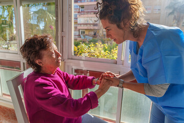 Compassionate nurse gently holding senior patient's hands, offering emotional care at home