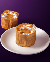 Cheese cupcake with some cream on it on the purple background