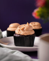 Classic white chocolate cupcake on the purple background