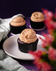 Classic white chocolate cupcake on the purple background