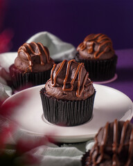 Swiss dark chocolate with some chocolate syrup on it cupcake on the purple background