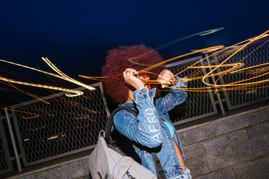 African descendent woman with afro hair playing with light trails