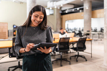 Coworkers in modern office collaborating with tablet technology