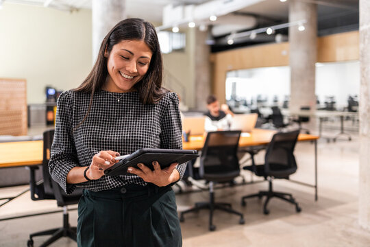 Coworkers in modern office collaborating with tablet technology