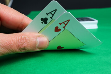 poker game male hand holding cards in green mass