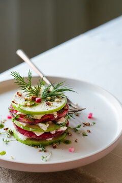 Gourmet vegetable stack salad on a white plate
