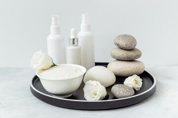 Blank white bottles of skin care cosmetics with roses