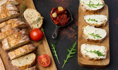 Cream cheese spread on ciabatta pieces and decorated with arugula leaves, appetizer