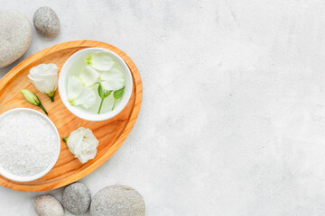 Tray on bathroom table with skin care cosmetics and white roses