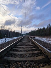 Natural view of empty railroad in forest, in sunny day. Rails and sleepers, railway close-up.