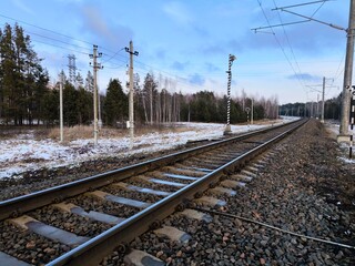 Natural view of empty railroad in forest, in sunny day. Rails and sleepers, railway close-up.