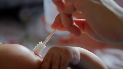 A baby is having his mouth and tongue cleaned using a baby oral cleaner.