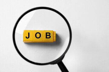 Job search concept. Word made with cubes on white background, view through magnifying glass