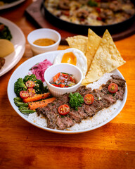beef steak bowl with rice, grilled veggies. Sunny side up and crispy crackers as topping on top. Served on white bowl. Perfect for menu, catalogue, advertising or commercial use