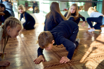 a group of pre-teens perform a teacher's task during an acting class, imitation of animals,...