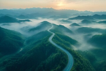 Winding road weaving through misty mountain peaks at sunrise