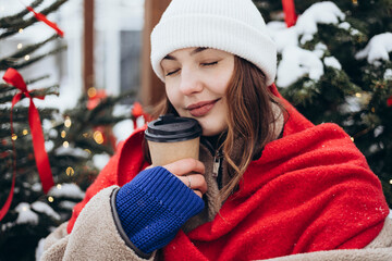 Young woman enjoying coffee on a snowy winter day