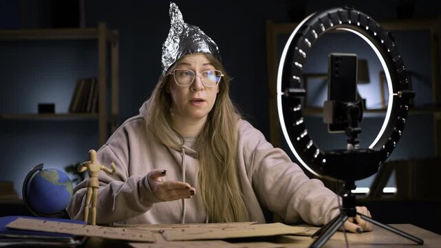 Strange crazy vlogger with cellphone, paranoid woman streaming at home conspiracy theory broadcasting in vlog, showing emotion closed mouth filled with water, gesture of silence. conspiracy