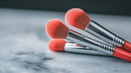 Close up of Three Red Makeup Brushes on Marble Surface Cosmetic Tools Beauty Products