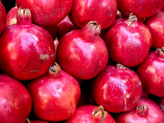 Pomegranate fruits food background. Group of many natural authentic red pomegranates, local fruits in the market, symbolizes fertility and abundance at Armenia country.