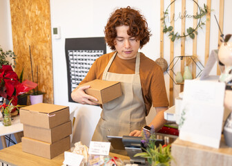 Retail cashier managing parcels at a shop organic store counter