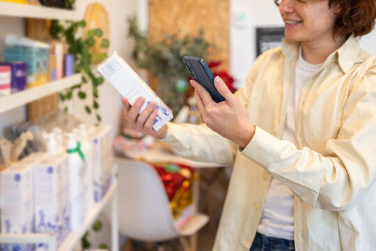 Customer using smartphone for barcode scanning in organic store