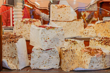 Large nougat pieces with nuts on display at market. Concept of sweet treats