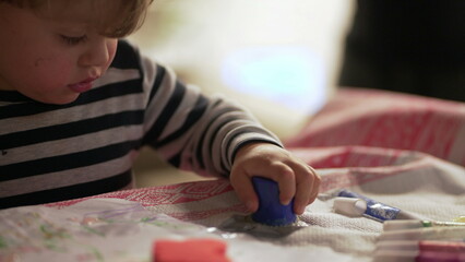 Baby playing with craft toys. Toddler plays with instrument toy