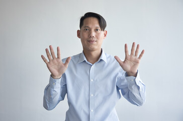 Healthy happy smiling middle aged southeast asian man pointing 10 fingers up, concept of ten...