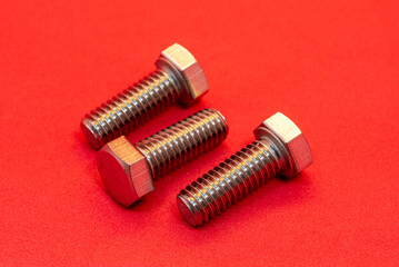 Bolts and nuts on a red background