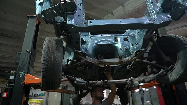 young mechanic repairs and installs an old gray car after a road accident (157)