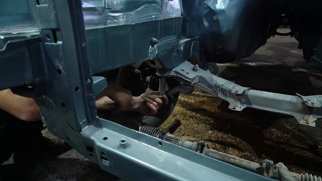 young mechanic repairs and installs an old gray car after a road accident (157)