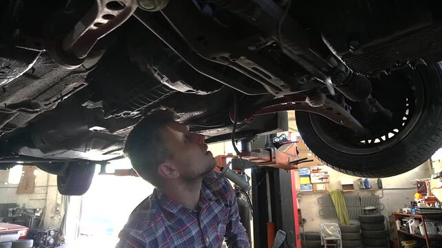 young mechanic repairs and installs an old gray car after a road accident (157)
