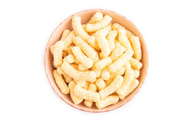 Corn flakes sticks with caramel in ceramic bowl isolated on white, top view, close up.