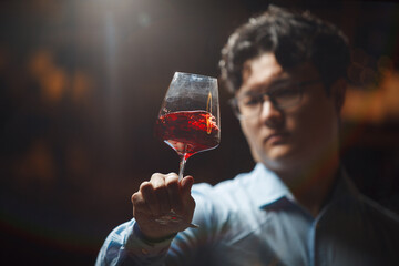 Professional Sommelier Evaluating Red Wine Quality in Dimly Lit Cellar