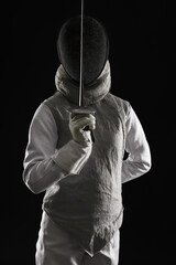 Fencer with epee on black background. Combat sport
