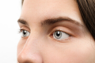 Closeup view of young woman with beautiful blue eyes on white background