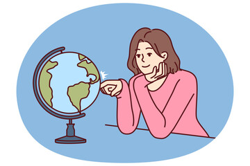 Woman dreams of traveling world looking at globe with planet earth and continents. Girl dreams of being tourist and going on trip to different countries and parts of world with distinctive culture