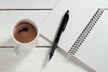 Cup of coffee, pen and notepad