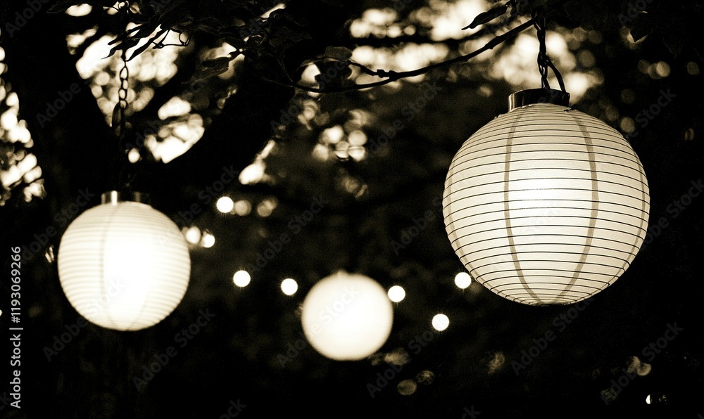 Poster glowing paper lanterns hanging from a tree at dusk, creating a festive atmosphere, ideal for event d