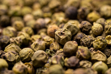 Dry green pepper spice close up. Green peppercorns macro view.
