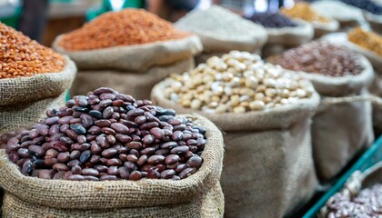 Obraz premium A market display featuring bags of different dried beans in sacks at a bazaar