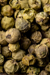 Dry green pepper spice close up. Green peppercorns macro view.