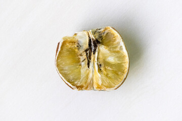 Top view of a rotten lemon cut in half on a white background.