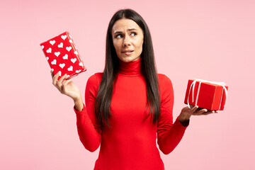 Doubtful woman choosing between two gifts on valentine's day