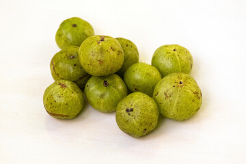 Amla fruits, scientifically known as Phyllanthus emblica and also called amloki, Indian gooseberry, emblic, emblic myrobalan, myrobalan, or Malacca tree, are isolated on a white background.