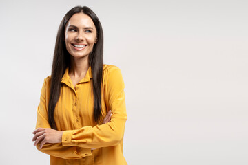 Smiling businesswoman crossing arms and looking away on copy space isolated on white background