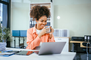 A cute African American businessman works diligently at his office desk, managing accounting tasks,...