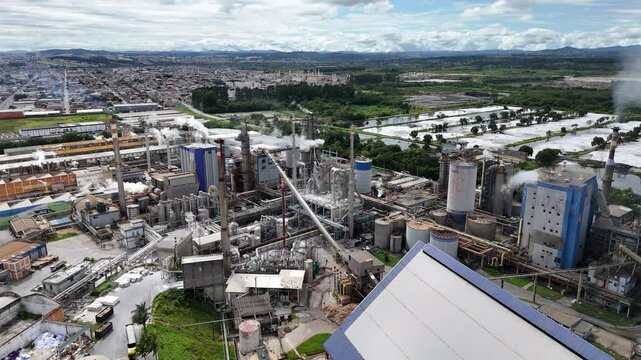 Ind&uacute;stria de papel e celulose com chamin&eacute;s e caldeiras em opera&ccedil;&atilde;o, destacando o processo produtivo e a emiss&atilde;o de vapor no setor industrial