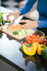 African American woman sitting  table, enjoying a colorful salad orange juice, highlighting the health benefits of five-color fruits vegetables, rich in antioxidants, reducing cancer risks,wellness